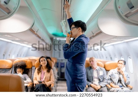 Airline staff man demonstration and explain about safety tools, oxygen mask, in the airplane to the passenger before the flight in airport area.