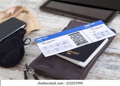 Airline ticket, passport and electronics, preparing to travel 