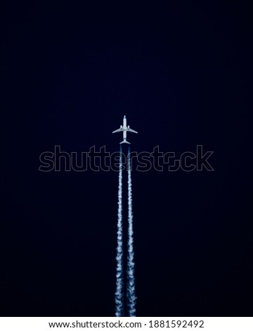airliner cruising on a high altitude with chem trails visible 