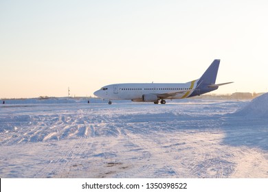 Airliner On Runway In Blizzard. Aircraft During Taxiing On Landing Strip During Heavy Snow. Passenger Plane In Snow At Airport.