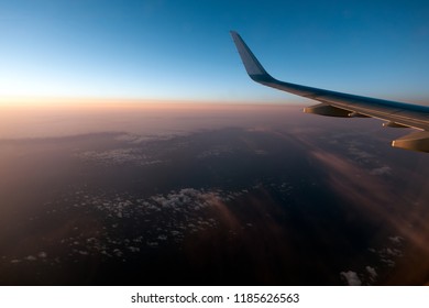 Airplain Wing Flying Over The Clouds With Blue Sky.