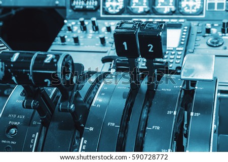 Airplan control stick in side pilot cockpit. Engine lever in the cockpit of an airliner. Center console and throttles in an airplane, blue colored