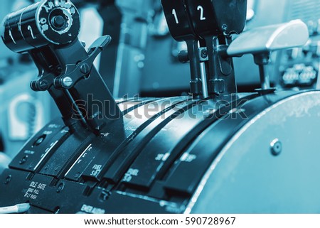 Airplan control stick in side pilot cockpit. Engine lever in the cockpit of an airliner. Center console and throttles in an airplane, blue colored