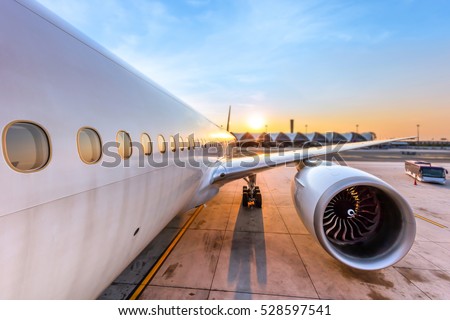 Airplane being preparing ready for takeoff in international airport at sunset - Travel around the world.