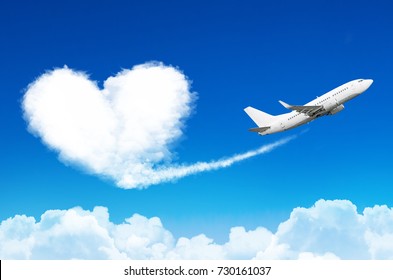 Airplane in the blue sky with clouds, left a trace in the form of a cloud of the heart