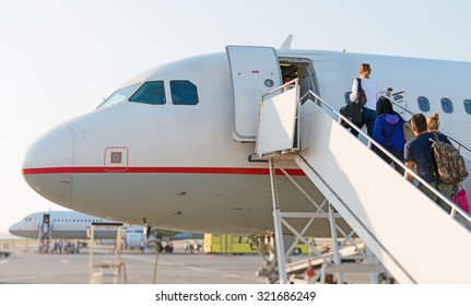 Airplane Boarding. Passengers Climb The Ladder.