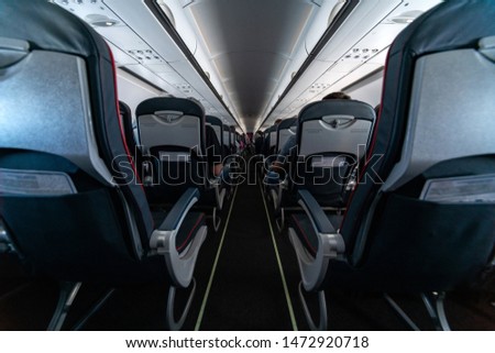 Airplane cabin seats with passengers. Economy class of new cheapest low-cost airlines without delay or cancellation of flight. Travel trip to another country.