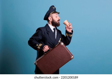 Airplane Captain In Professional Airline Uniform Running Late, Carrying Baggage, Drinking Coffee To Go. Caspitan With Suitcase In Airport, Aviator With Baggage Holding Tea Paper Cup, Side View