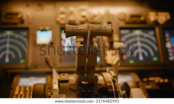 Airplane captain\
taking off and throttling engine to fly aircraft, using dashboard\
command with power buttons and lever. Windscreen and control panel\
used by aircrew. Close\
up.