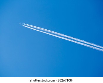 Airplane contrail against clear blue sky