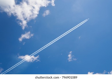 Airplane Contrail Against Skyblue Sky With White Cloud .