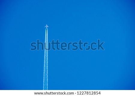 Airplane contrail against solid clear blue sky.