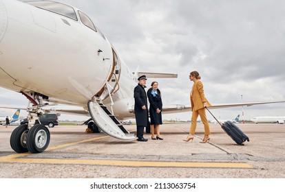 Airplane crew leads woman in yellow clothes inside of a plane.