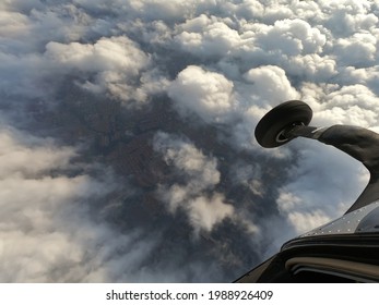 Airplane Door Open In Mid-flight. Above The Clouds The Skydiver Looks On.