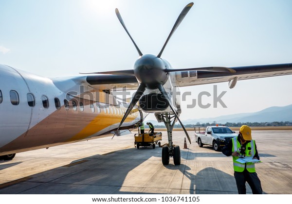 The airplane engineer of Nok Air flight is checking the\
plane before leaving, aircraft name is Bombardier Dash 8 Q400 at\
Chiang Mai airport , Thailand.\
This picture is taken 26 Feb 2018\

