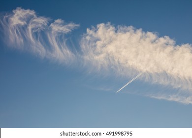 Airplane flies through a jetstream cloud formation