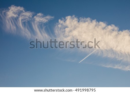 Airplane flies through a jetstream cloud formation