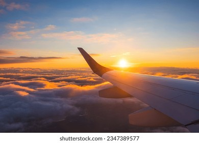 Airplane flight in sunset sky over ocean water and wing of plane. View from the window of the Aircraft. Traveling in air. - Powered by Shutterstock