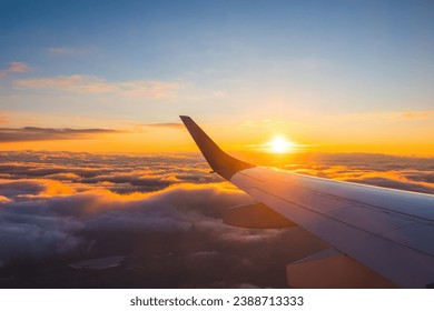 Airplane flight in sunset sky over ocean water and wing of plane. View from the window of the Aircraft. Traveling in air. - Powered by Shutterstock