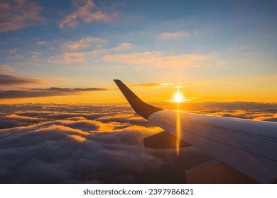 Airplane flight in sunset sky over ocean water and wing of plane. View from the window of the Aircraft. Traveling in air. - Powered by Shutterstock