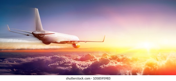 Airplane flying Above Clouds At Sunrise
 - Shutterstock ID 1058595983