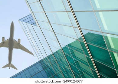 Airplane flying above modern sustainable glass office building. Exterior skyscraper green glass building. Business travel. Aviation business. Air logistics. Cargo plane. Eco-friendly architecture. - Powered by Shutterstock