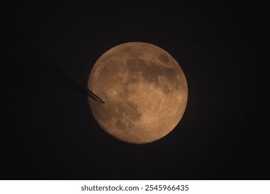 Airplane flying against the background of the moon. Contrail. The moon in the night sky.  - Powered by Shutterstock