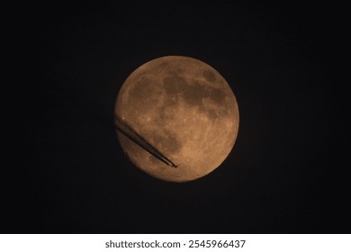 Airplane flying against the background of the moon. Contrail. The moon in the night sky.  - Powered by Shutterstock