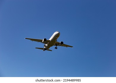 Airplane Flying In The Blue Sky.