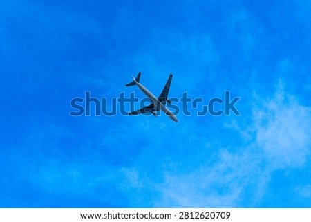 Airplane flying high in clear blue sky.