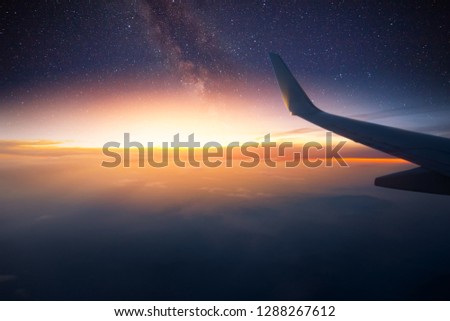 Airplane is flying at night. Space Milky Way view from plane window. Dark clear starry sky