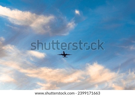 Airplane Flying on the blue sky with sunset clouds 