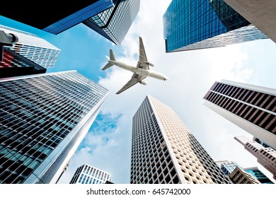 Airplane flying over business skyscrapers - Powered by Shutterstock