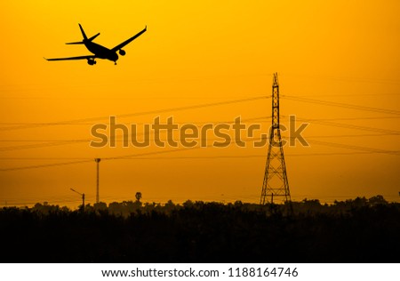 Airplane flying over the electtric pole at sunset. Stock photo © 