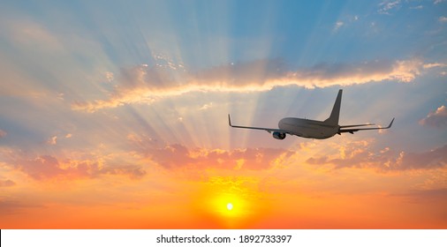 Airplane flying over tropical sea at sunset - Powered by Shutterstock