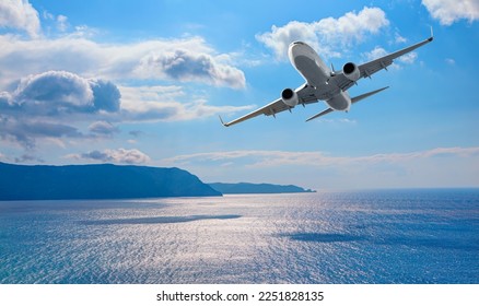 Airplane flying over tropical sea at sunset - Powered by Shutterstock