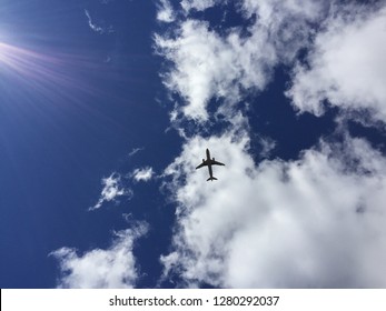 An airplane flying overhead through the clouds 