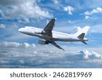 Airplane flying in the sky, travel background with commercial flying airplane with blank livery