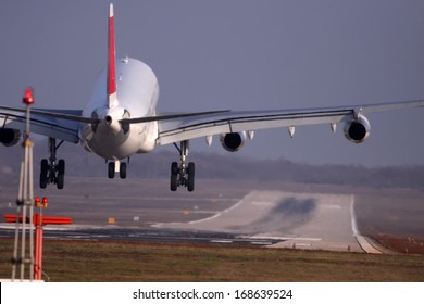 Airplane With Four Engines Landing On Runway Back View - Moments Before Touchdown