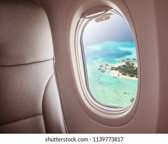 Airplane interior with window view of Maldives island. Concept of travel and air transportation