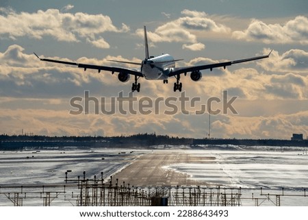 Airplane landing to airport runway at sunset