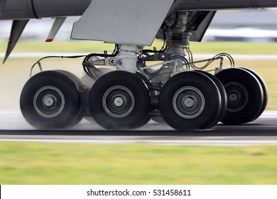 Airplane Landing Gear Rolling On A Wet Runway.