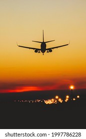 Airplane Landing On The Runway During Sunset And Night