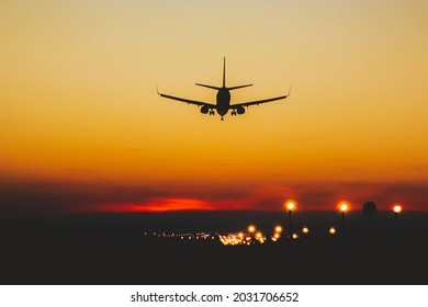 Airplane Landing On The Runway During Sunset And Night