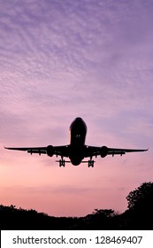 Airplane Landing At Sunset