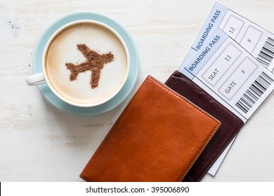 Airplane made of cinnamon in coffee. 
Cup of coffee, passports and no name boarding passes.
Traveling concept. Cappuccino in airport 