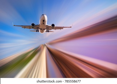 Airplane In Motion Over Roadway On Blur Blue Sky Background