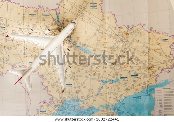 Airplane over an aeronautical map with charts.\
Travel around the world\
concept