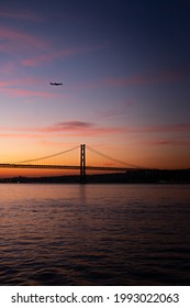 Airplane over a Bridge in Lisbon during Sunset