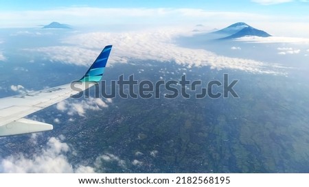 airplane over mountains and clouds. this is a Garuda Indonesia the airlines from Indonesia